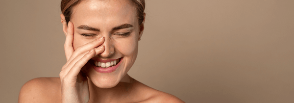 Woman laughing and enjoying their simple skin care routine.