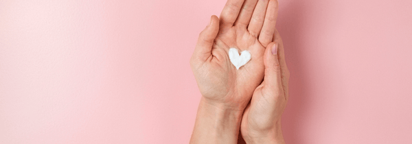 Thentix skin conditioner on smooth hands in the shape of a heart.