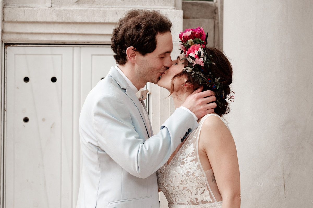 Peony Rice Bride Melda in her custom embroidered tulle wedding gown kissing her groom