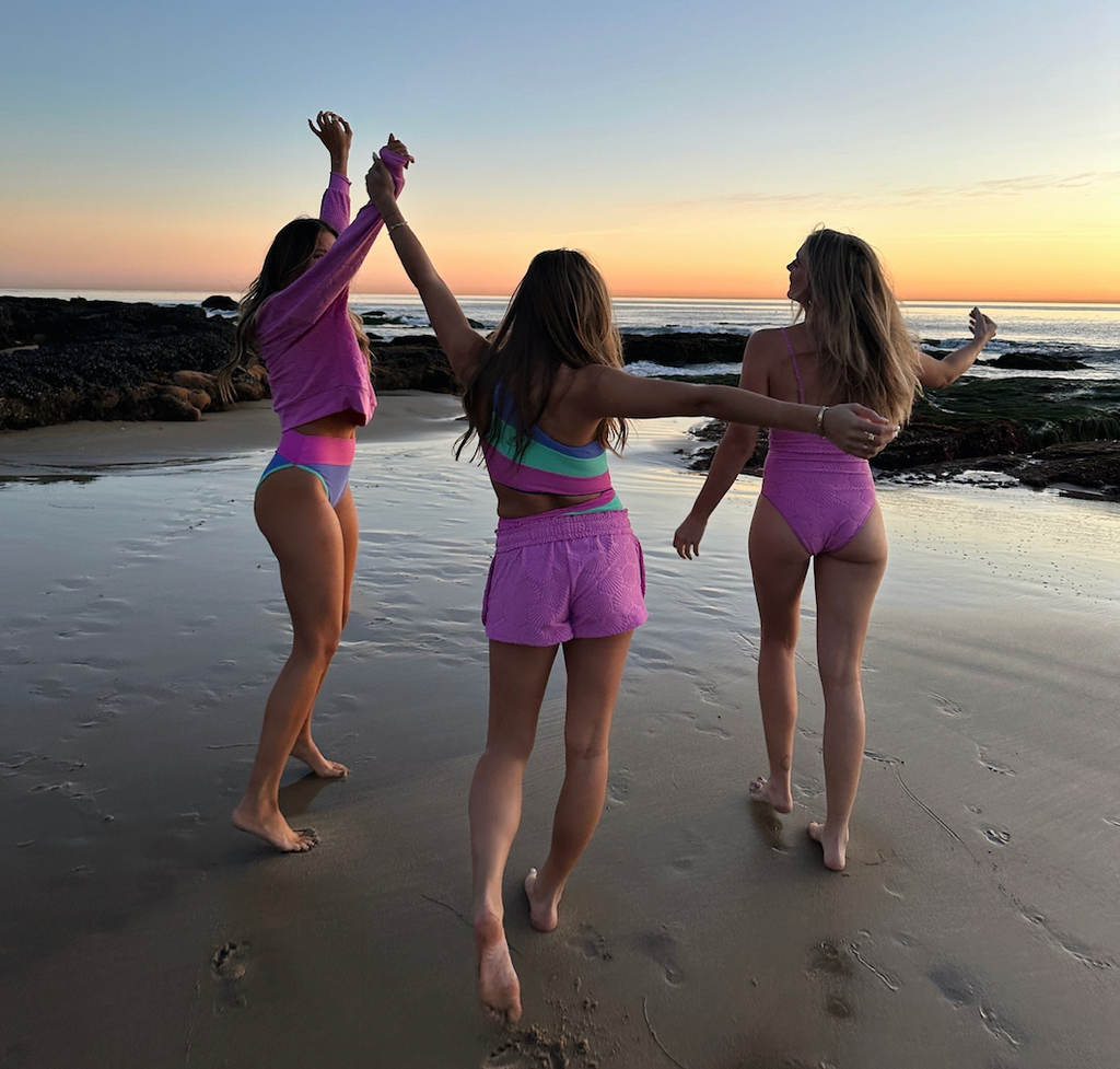 Girls dancing in swim by the ocean