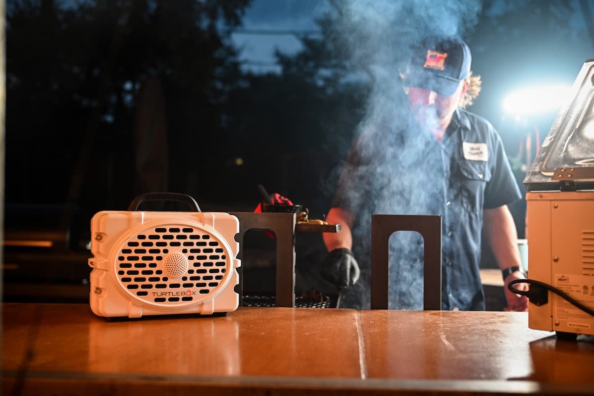 Matt Pittman cooking behind the BBQ smoke and listening music on a Turtlebox.