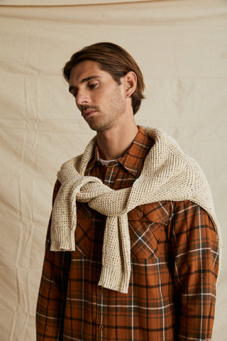 guy standing wearing flannel shirt with knit tied over the top