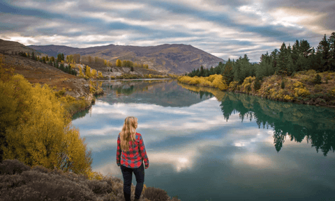 girl standing on the corner of river