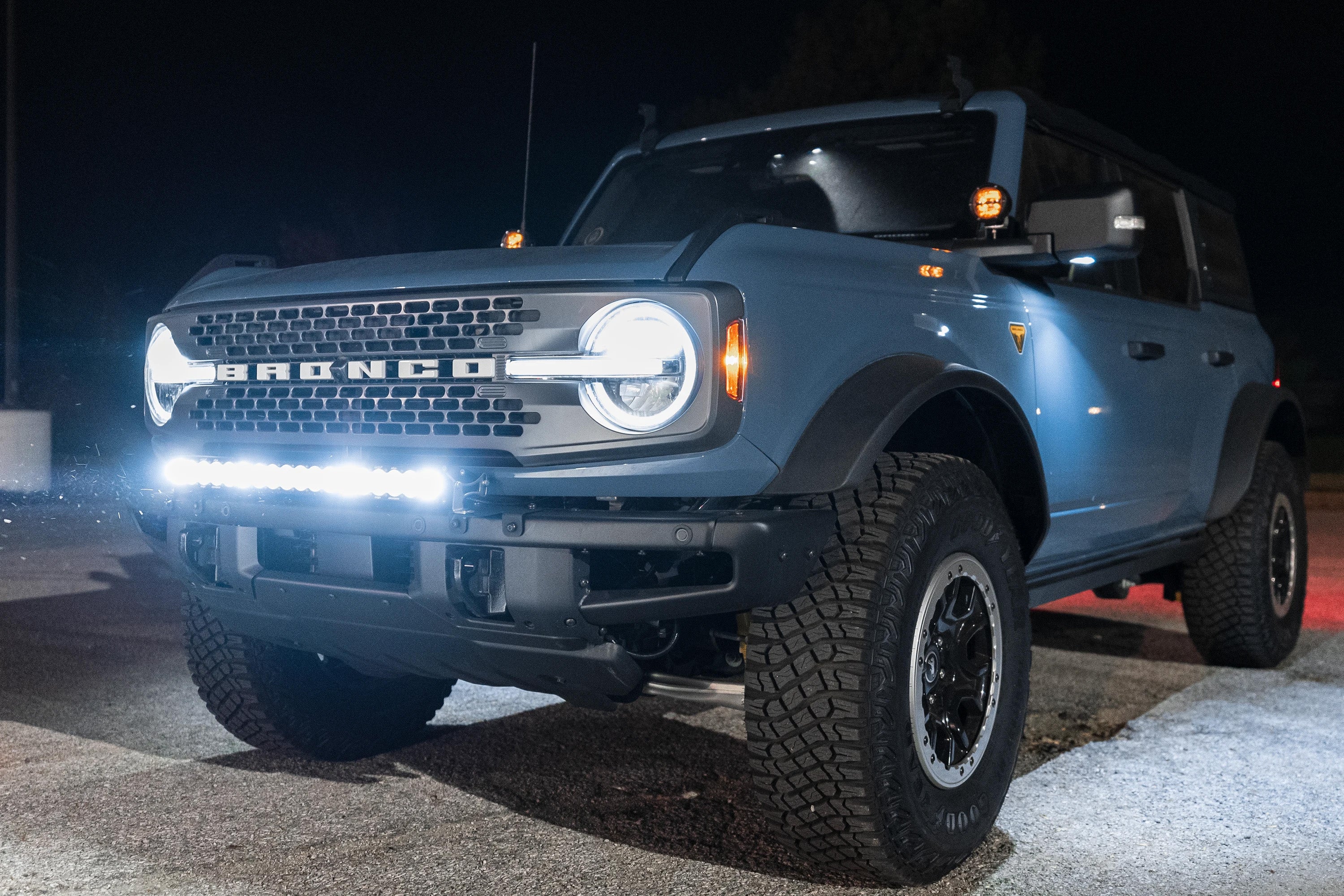 ford bronco with lights on in a parking lot