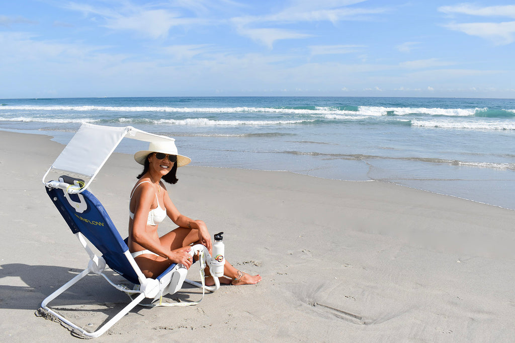 Leslie in a white bathing suit sitting on a ocean navy colored Sunflow chair at Delray Beach