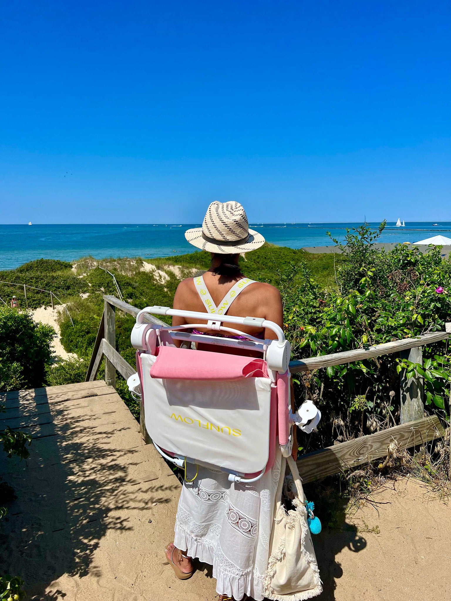 Leslie holding the rosé pink chair on her back