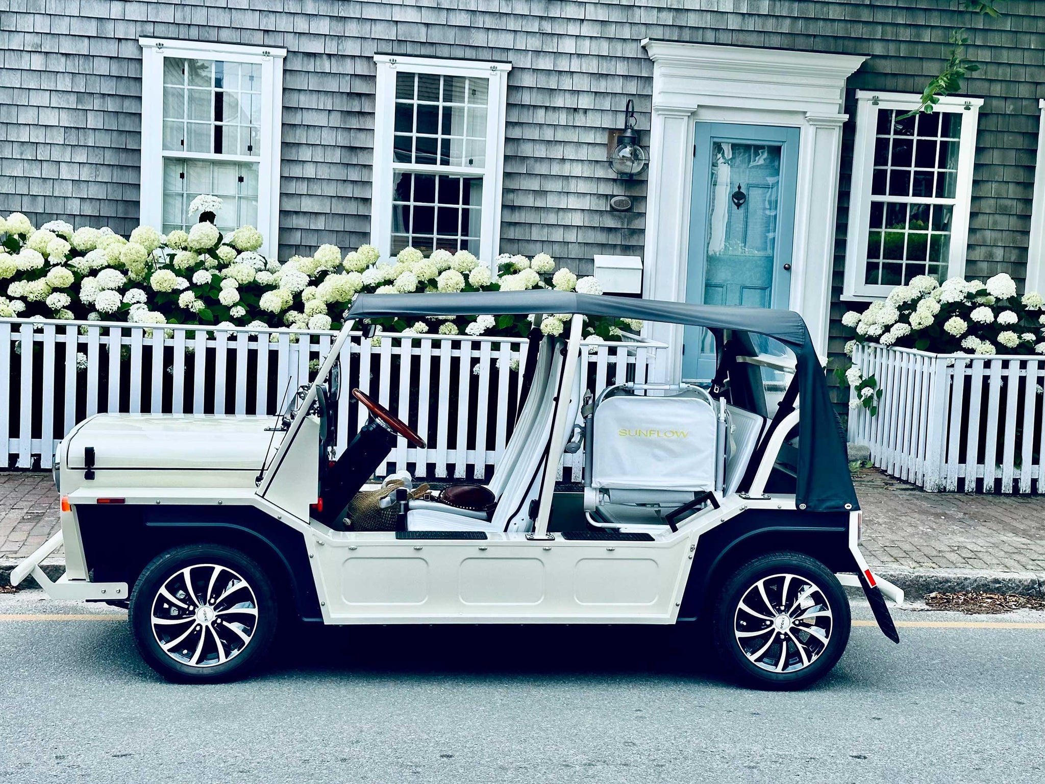 a white Moke parked in front of a home