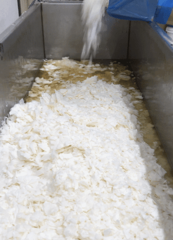pouring soy wax flakes into melter