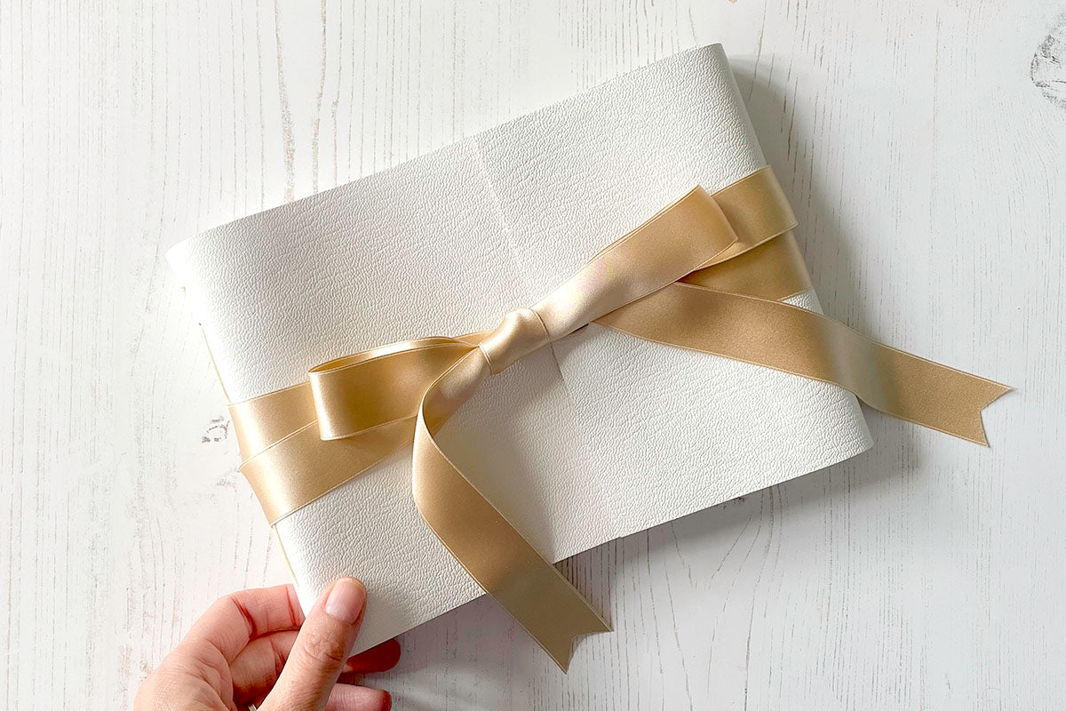 Wedding Guest Book bound in white leather with natural silk ribbon