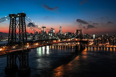 lighted cable bridge near high-rise buildings