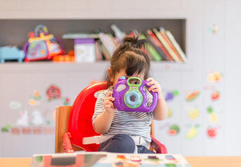 Child holding a toy camera