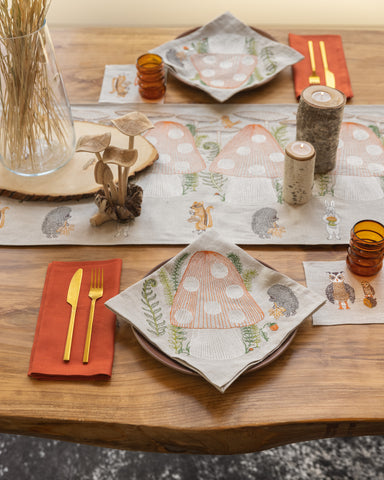 Dinner table set with Coral & Tusk Mushroom Forest Table runner and dinner napkins, wood mushrooms and candles