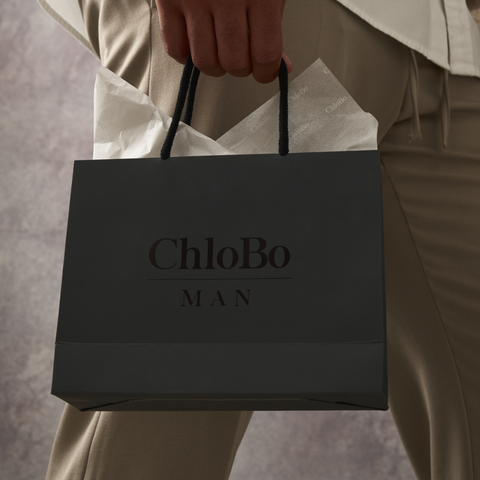 Man holding a black ChloBo Man Branded Bag