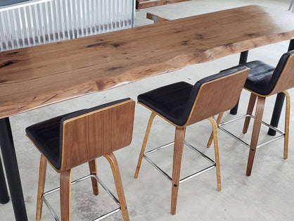 A long and skinny custom table top with wooden backed chairs