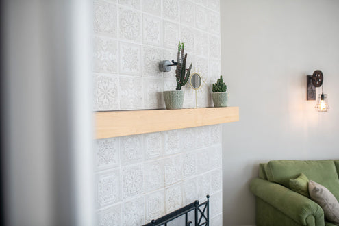 Light wood mantel slab with plants and a white mantel