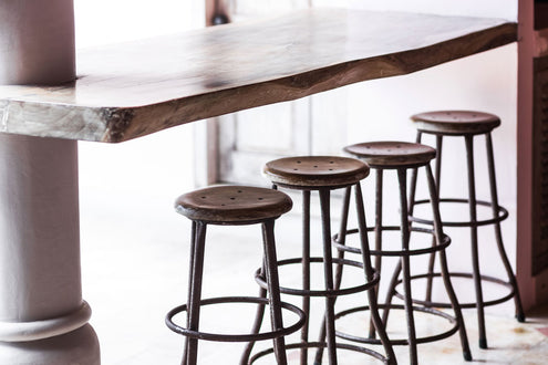 A live edge bar top with metal bar stools