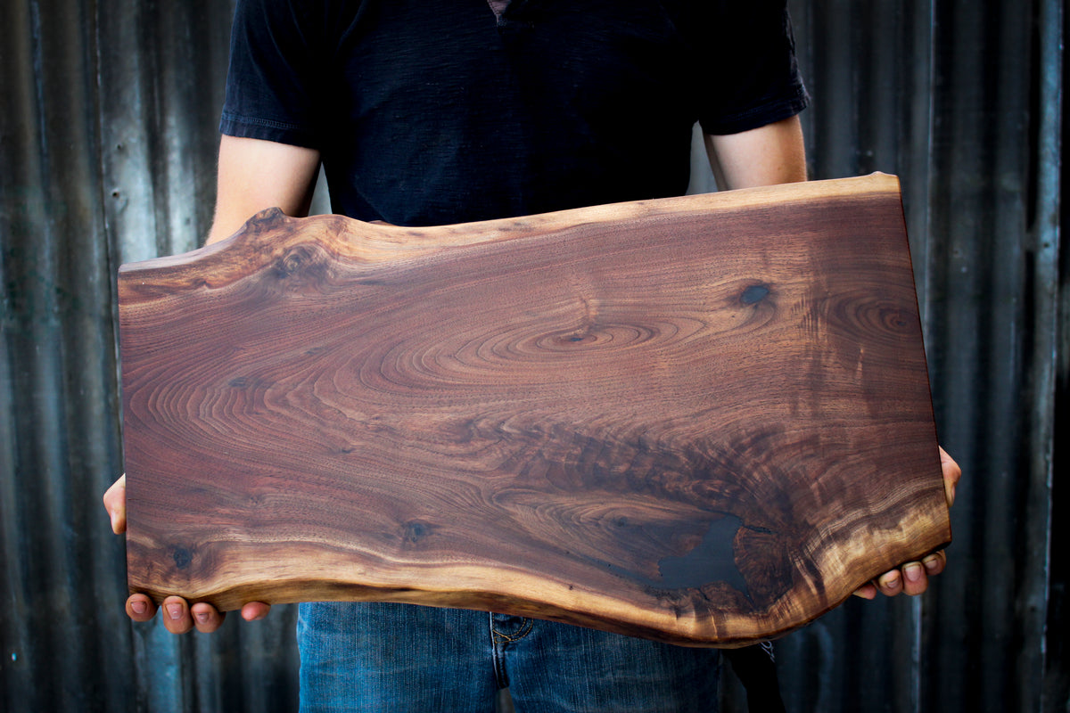 Man holding a dark walnut wood slab