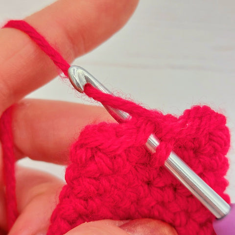 4.	Wrap the yarn around the hook, ready to be pulled back through the stitch.