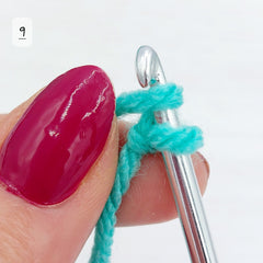 Holding firmly onto your yarn and hook, catch the wrapped strand of yarn fully under the crochet hook.