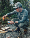 man lighting wood on fire 