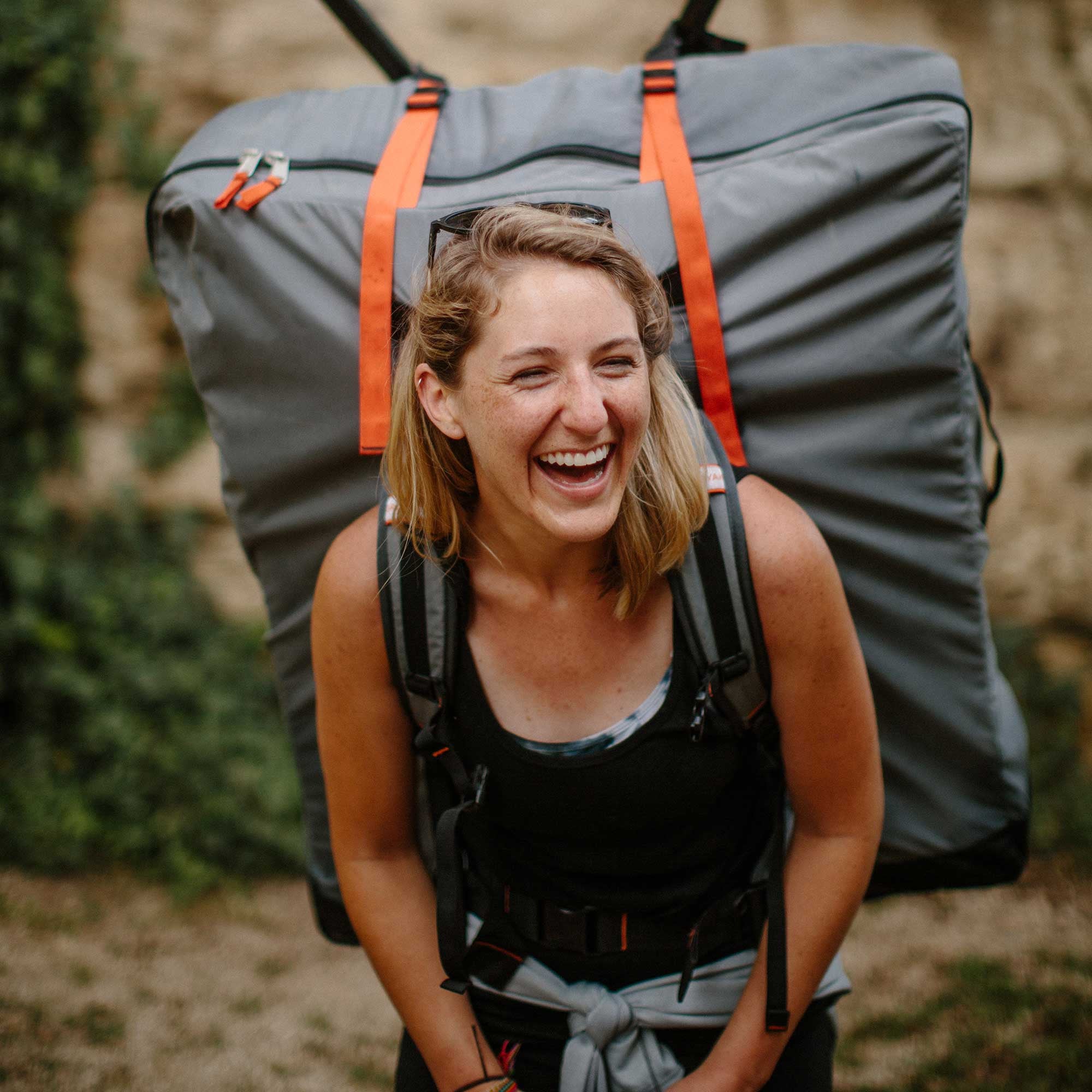 woman carrying kayak inside the oru carrying pack 