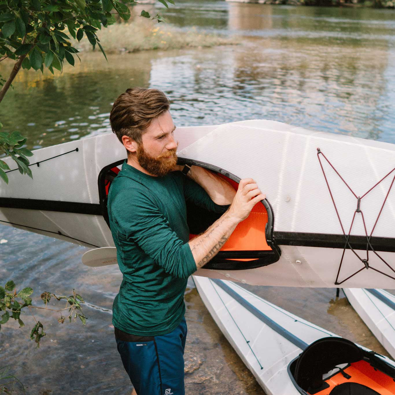 man carrying his bay st kayak