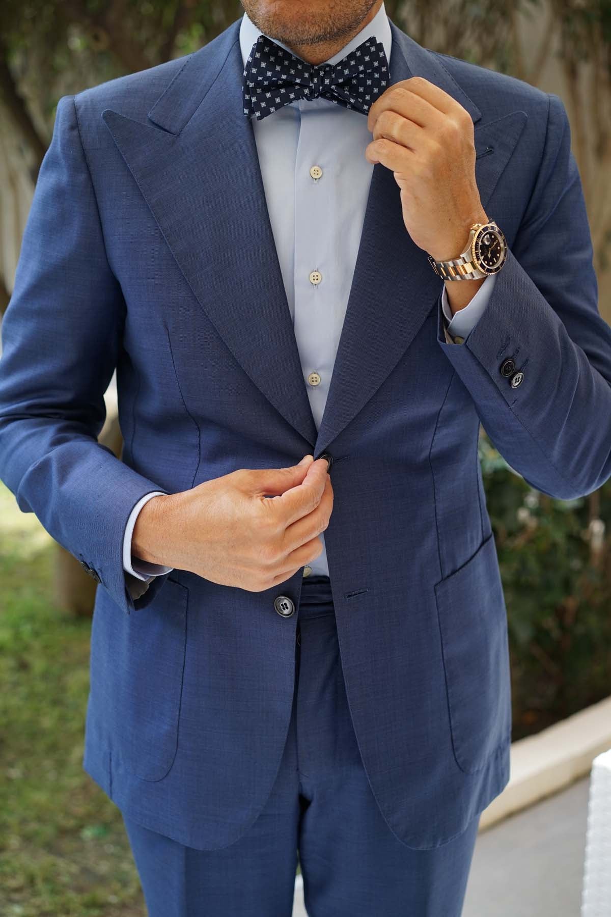 Man wearing a navy blue self-tie bow tie with light blue pattern