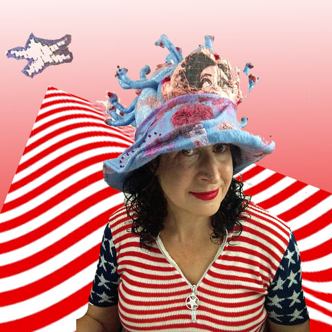 Pink and Blue Covid-19 inspired hat against a red and white striped background.