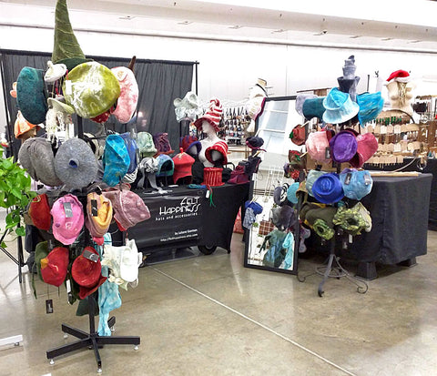 Photo of my felted hats arranged on hat rack and table at last year's Handmade Arcade.