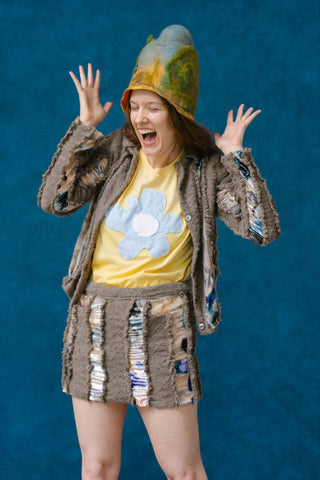 From Refigural Magazine -- Woman looking surprised while wearing a felted hat and a bark-patterned skirt