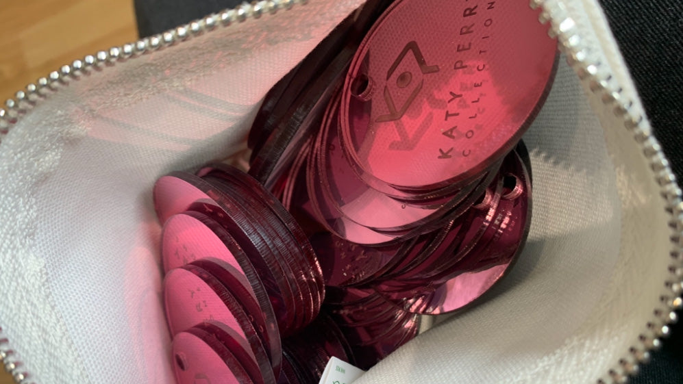 Mirrored pink acrylic tags - engraved with the Katy Perry Collections logo. Made bespoke by Parkin and Lewis.