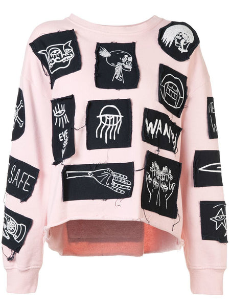 Black and white patches on pink sweatshirt