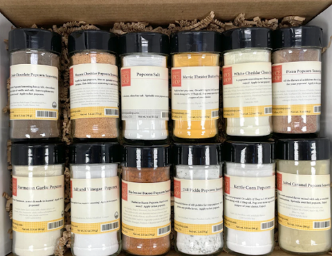 photo of a gift box with 12 different flavors of popcorn seasoning inside