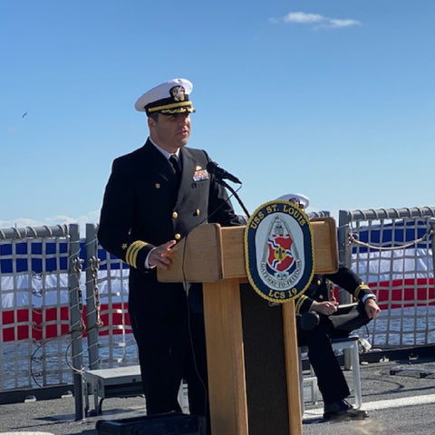 jon delivering speech at podium on flight deck of ship