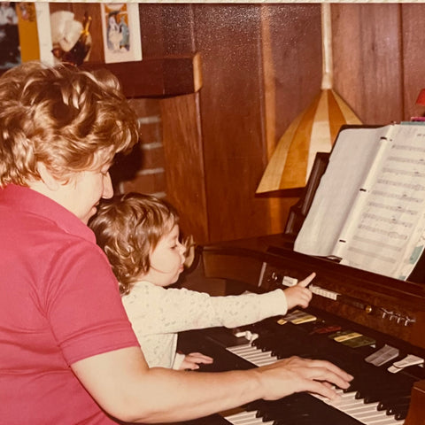 woman and little girl playing the organ with sheet music