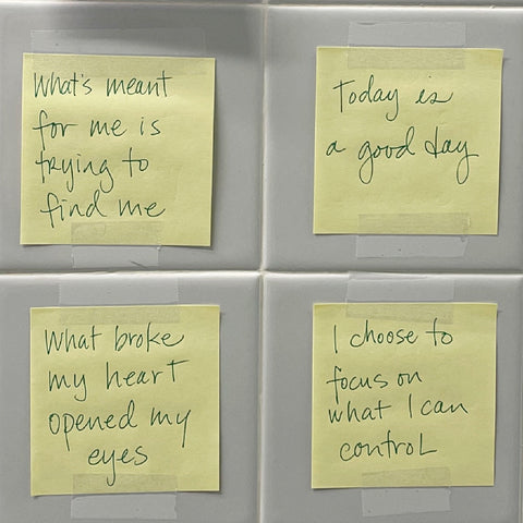 post it notes taped to a grey tile bathroom wall - each has a saying - "what's meant for me is trying to find me", "what broke my heart opened my eyes", "today is a good day", "I choose to focus on what I can control"