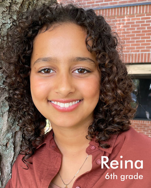 tan young woman with curly hair who is smiling - named Reina, 6th grade