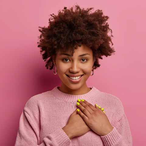 black woman with her hands over her heart looking happy