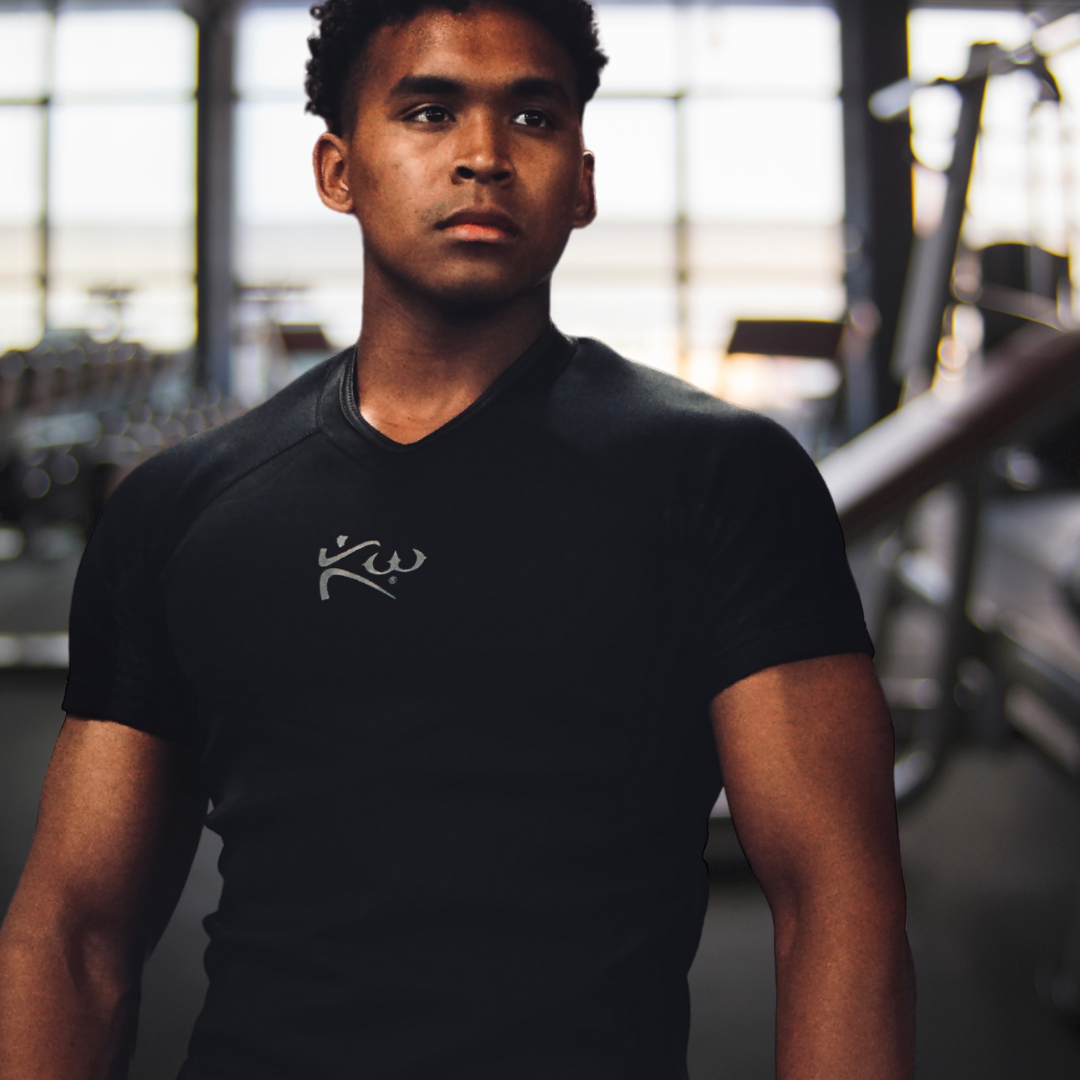 Close-up view of man standing in gym wearing Kutting Weight black neoprene sweat suit