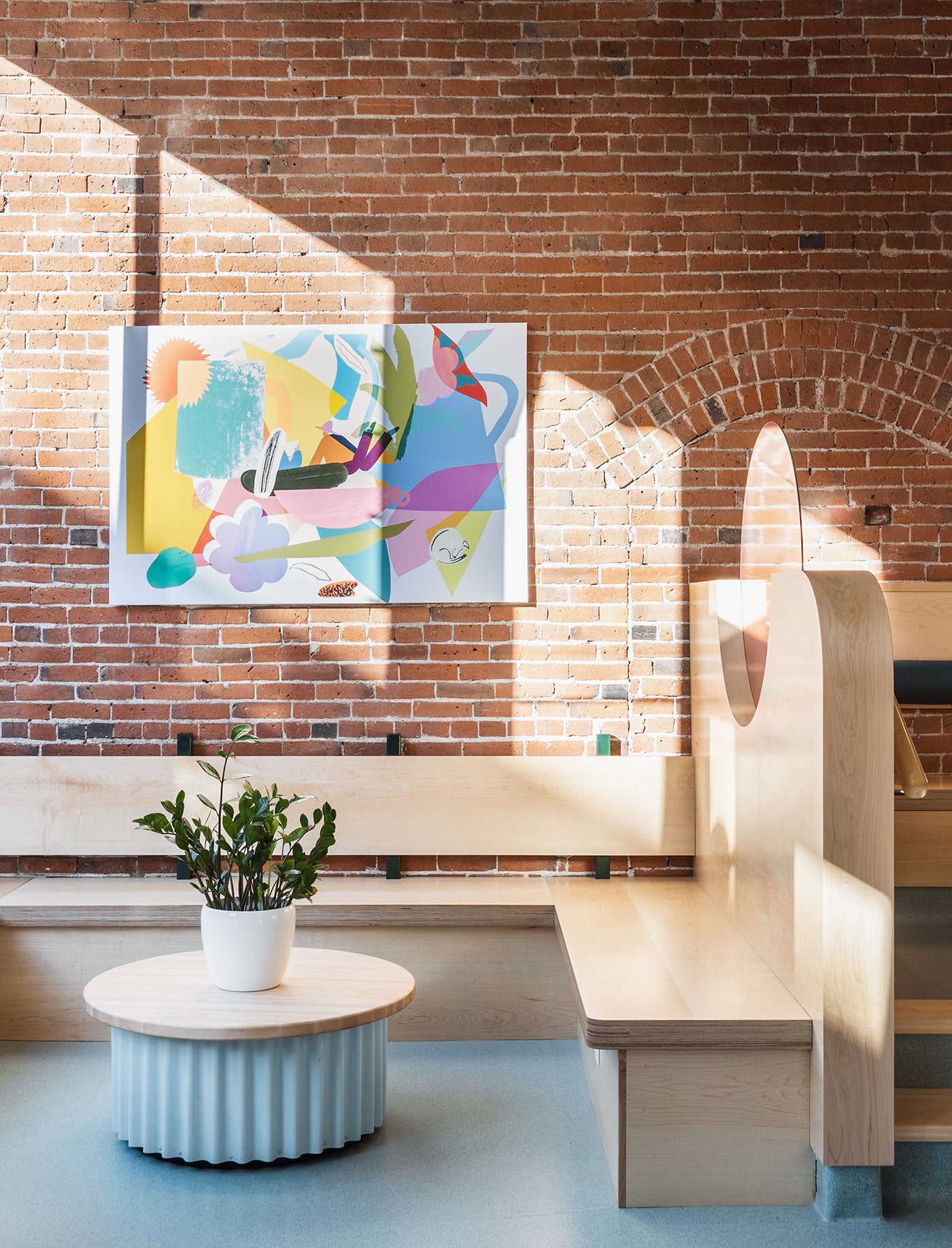 Bright modern cafe interior design featuring abstract art on brick wall