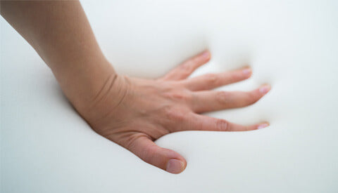 A Close-Up View of a Hand on a White Mattress