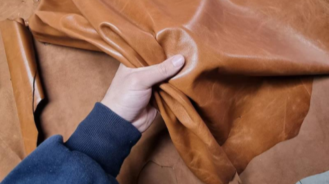 A Close-Up View of A Man Hand Checking and Testing the Full Aniline Top Grain Caramel Brown Leather.