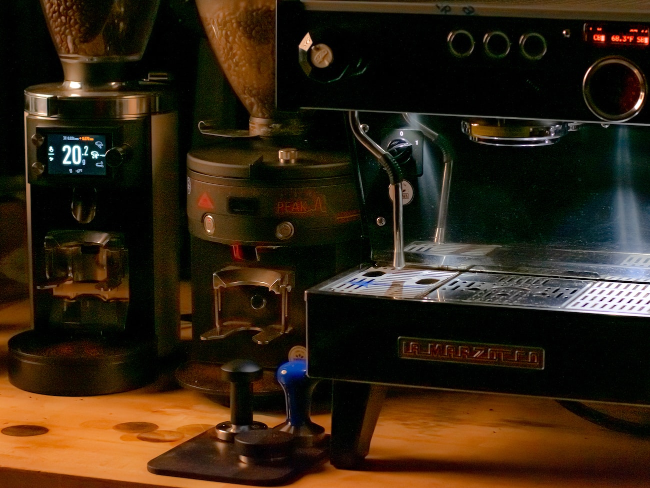 Espresso machine next to tampers and grinders