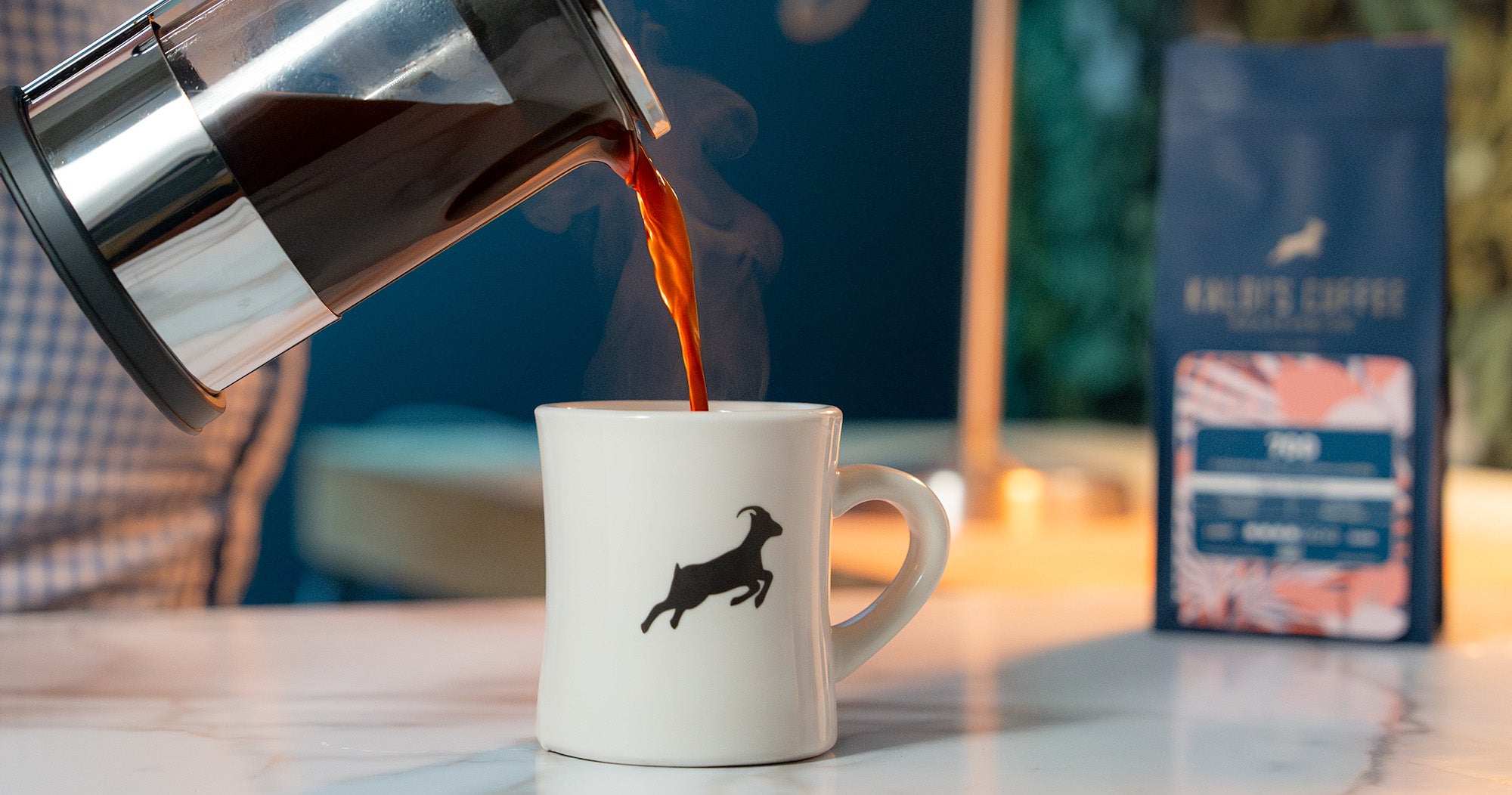 A french press pours into a Kaldi's diner mug