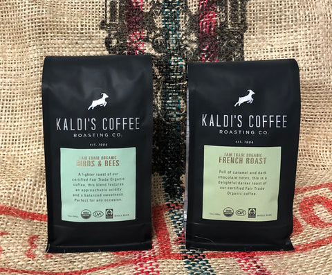 A black 12oz bag of Fair Trade Organic Birds & Bees and a black 12oz bag of Fair Trade Organic French Roast on a burlap coffee bag