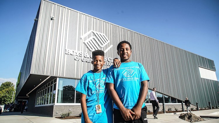 Two children from the Boys and Girls Club program standing in front of the building