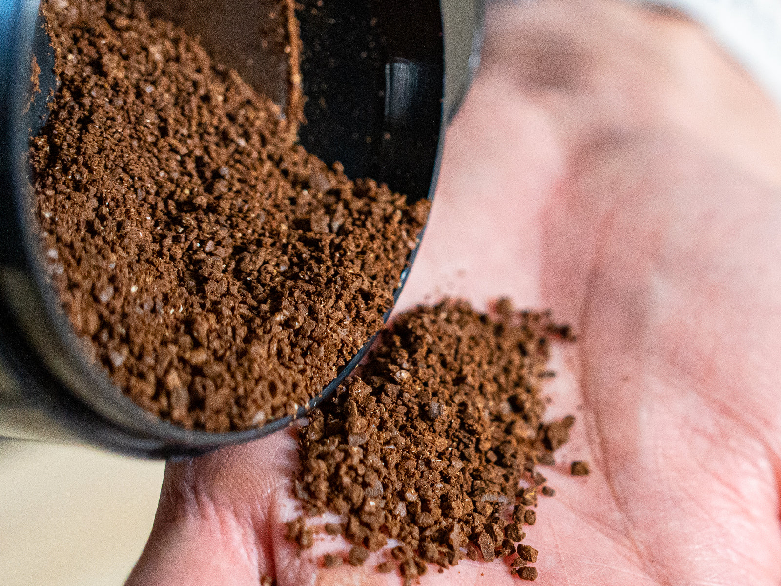 Close up of the coffee grinds coming from a blade grinder. You can see big chunks and powder mixed together.