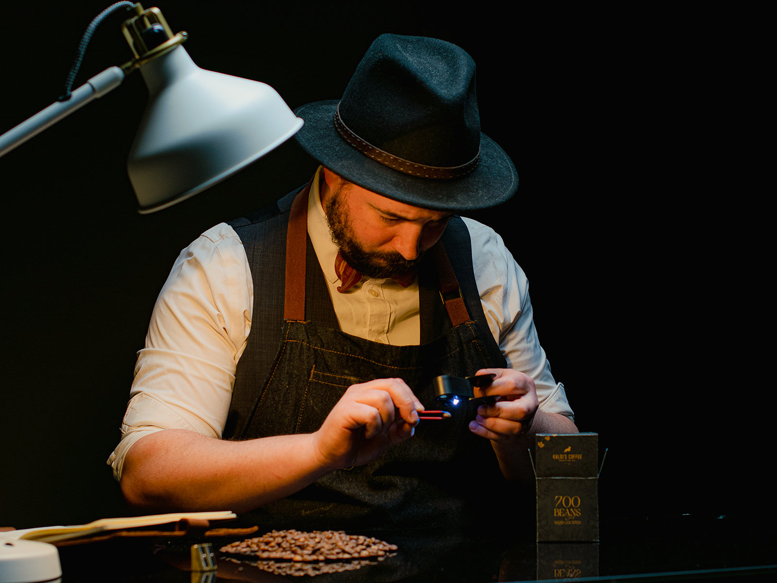 A roaster examines a single coffee bean