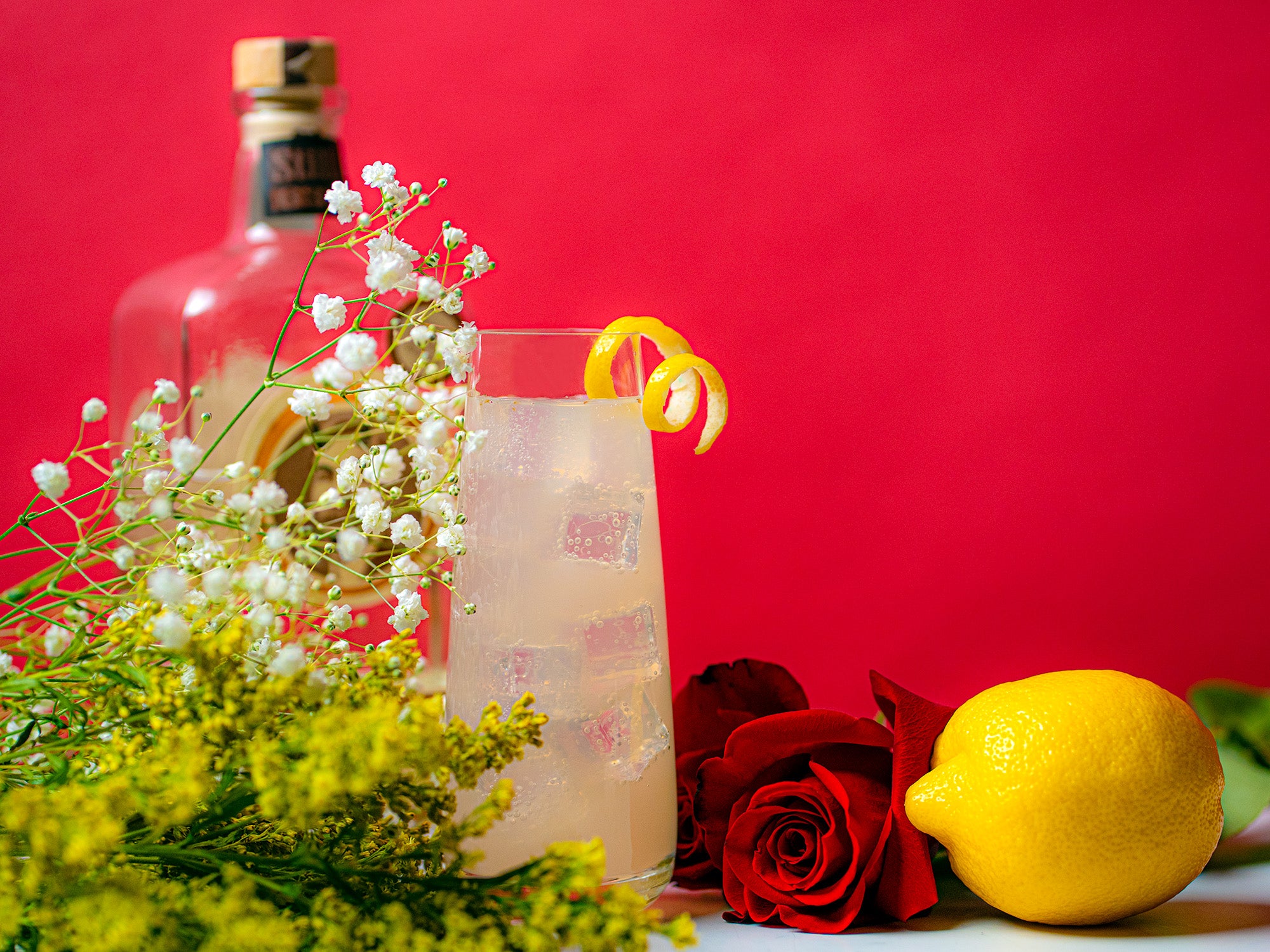 Indian Rose Gin Zinger with flowers and a bottle of Still 630 gin