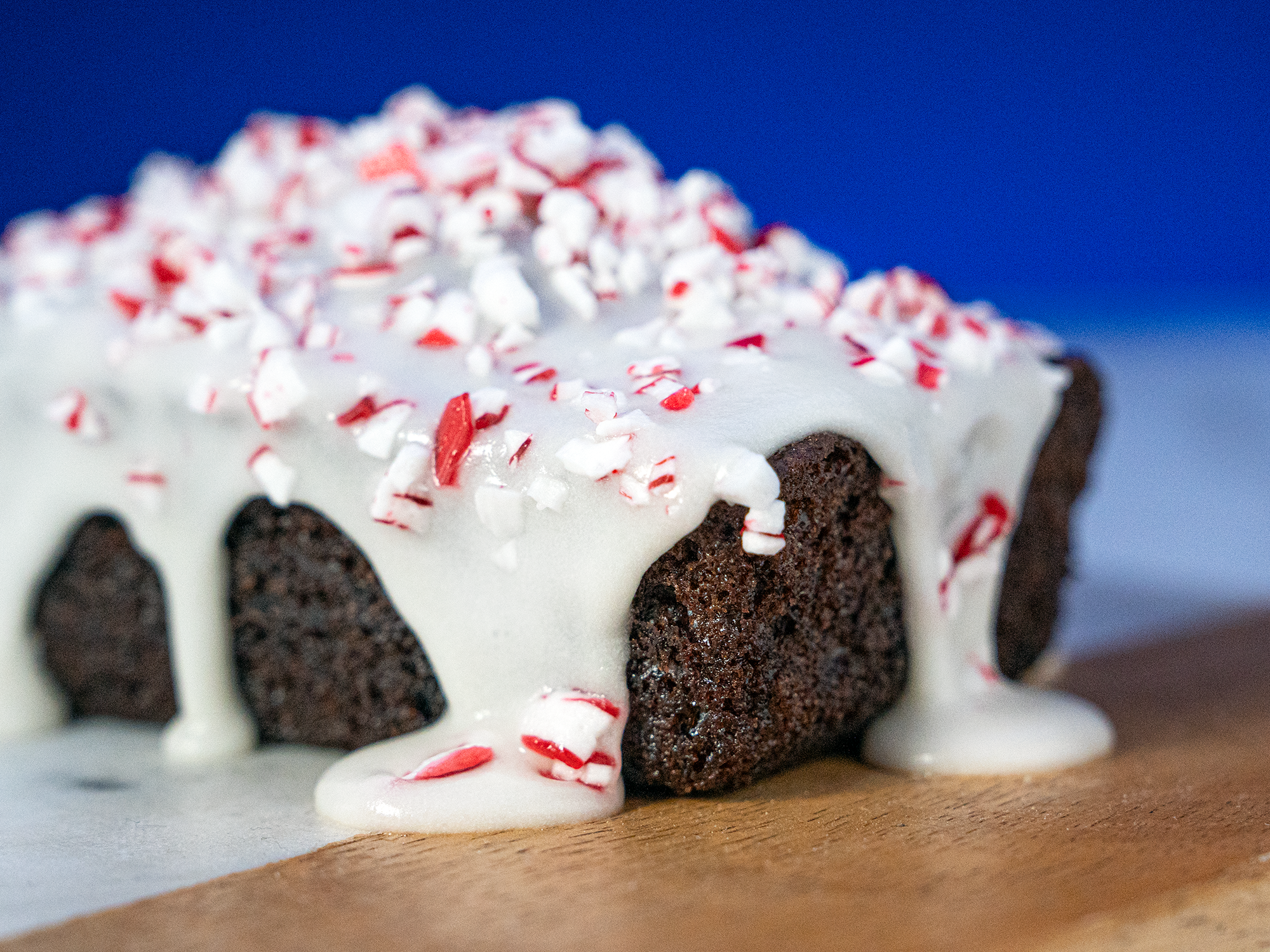 A Peppermint Chocolate Loaf drips with icing on a cutting board